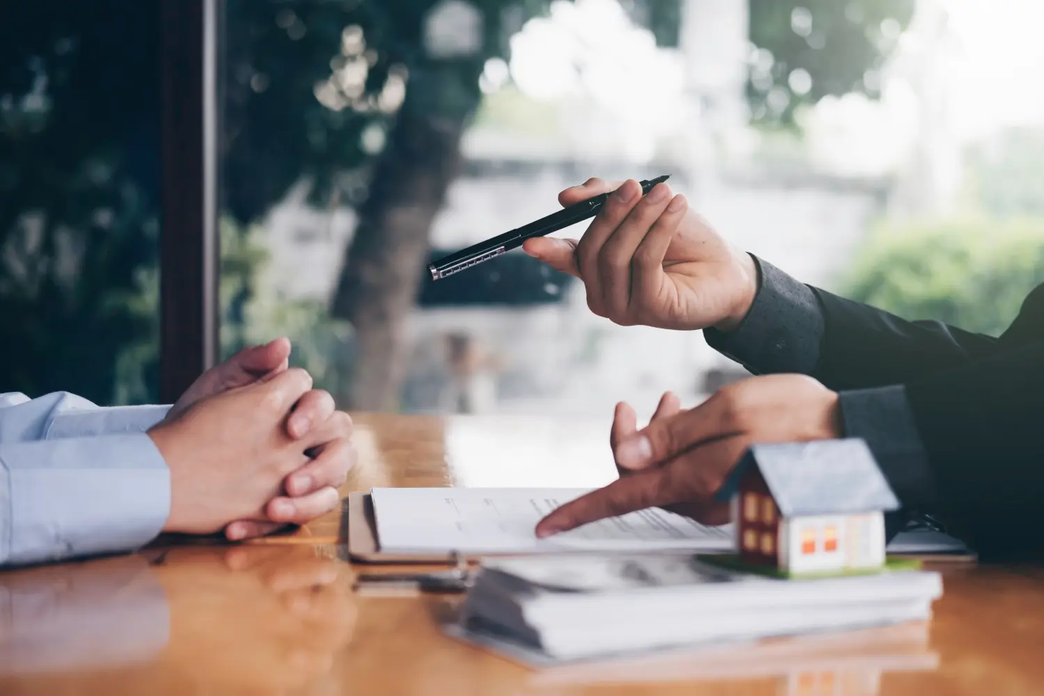 Nahaufnahme der Hand eines Immobilienmaklers, der einen Stempel hält, um die Dokumente für den Immobilienkauf abzustempeln. 